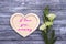 Decorative white wooden heart on grey wooden background with lettering Happy Mother`s Day.