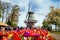 Decorative windmill in Keukenhof park. Tourists walking in blossom colorful tulip field