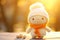 Decorative winter-themed knitted figurine. Cute knitted character in kawaii hat on sunny background