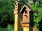 Decorative wooden birdhouses on bars stand in the park on a sunny day. Closeup photo