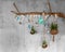 Decorative Wooden Branch with fir branches and hanging teal christmas baubles, silver lights like snowflakes, fern and air plant,