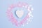 Decorative wooden heart with pink glitters on a pastel blue background