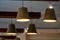 A decorative wooden lampshade with an energy-saving diode lamp is hanging from the ceiling. Unusual designer chandeliers made of