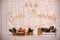 Decorative wooden sign sweet home with lights glowing garlands on wall christmas room. On white shelf there is a candlestick in  s