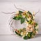 Decorative woven wreath is decorated with flowers and quail eggs.