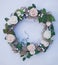 Decorative wreath decorated with artificial flowers, leaves, lace and mistletoe