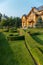 Decoratively trimmed lawn at the entrance to the chic large wooden house
