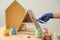 Decorator painting pyramid shaped shelf with brush at wooden table, closeup. Interior element