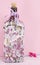 Decoupage decorated bottleagainst pink background