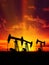 Decrease in oil production in world. Oil pumps are silhouetted against a sunset