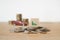 Decreasing graph sign on wooden cube block on pile of coins with blurred stack of coins and red miniature car