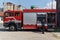 A dedicated firefighter preparing a modern firetruck for deployment to hazardous fire-stricken areas, demonstrating