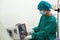 A dedicated healthcare professional in a sterile surgical gown maneuvers a high-tech machine, the latest in medical advancements,