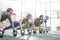 Dedicated people doing pushups with kettlebells at crossfit gym
