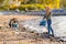 Dedicated smiling young volunteers cleaning beach for plastic on sunny day