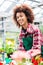 Dedicated woman holding a potted plant during work as florist