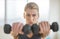 Dedicated Woman Lifting Dumbbells At Health Club