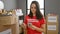 Dedicated young hispanic woman in uniform, beauty counting donation dollars with seriousness at indoor charity center, a portrait