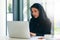 Dedication and technology. Essential for getting her tasks done. a young muslim businesswoman using a laptop at her work