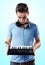 Deejay with headphones holding midi keyboard in hands