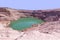 Deep blue Hidden Lake in Timna surrounded by the red cliffs of Eilat