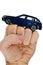 Deep blue metallic model of modern wagon car placed on raised fist of adult male person, white background