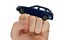 Deep blue metallic model of modern wagon car placed on raised fist of adult male person, white background