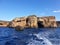 Deep blue sea with cruel foaming waves and the rough limestone rocks of Malta islands