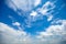 Deep blue sunny sky with white clouds. Blue sky with cloud closeup. White fluffy clouds in the blue sky