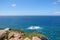 Deep blue water of calm Atlantic Ocean with small waves hitting rocks.