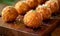 Deep fried arancini balls on wooden board - traditional Italian cuisine. Stuffed rice balls