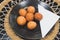 Deep fried balls made from green banana sitting on black plate, traditional latin american food, classy table setting