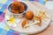 Deep fried cheese ball and french fries on wood dish