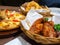 Deep fried chicken in a basket with parsley and seafood pizza topping with Crab, shrimp and ham On a wooden tray and Onion Rings i