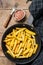 Deep fried Crinkle French fries potatoes sticks in a pan. Wooden background. Top view