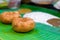 Deep fried gram pulses sambar vada placed on a green banana leaf and served with coconut chutney at a street food stall