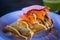 Deep-fried, hard-shell crab taco topped with salsa, slaw, and radish on a white plate