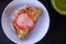 Deep-fried, hard-shell crab taco topped with salsa, slaw, and radish on a white plate