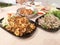 Deep fried pork intestines topped with crispy garlic and pepper and Cabbage, finely sliced on black plate, Ground pork salad,