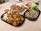 Deep fried pork intestines topped with crispy garlic and pepper and Cabbage, finely sliced on black plate, Ground pork salad,