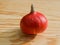 Deep orange pumpkin lying on a wooden table top