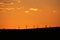 Deep orange skies behind silhouetted windmills