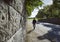 Deep perspective along a stone wall and a man walking in an autumn street.