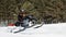 In deep powder snowdrift snowmobile rider driving fast