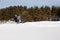 In deep powder snowdrift snowmobile rider driving fast