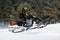 In deep powder snowdrift snowmobile rider driving fast