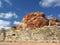 Deep red outback rock formation under blue sky