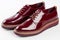 Deep red shiny pair of shoes on a white background.