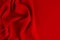 Deep red silk smooth wavy background with copy space