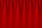 Deep red velvet curtain with smooth folds as elegance classic cinema background.